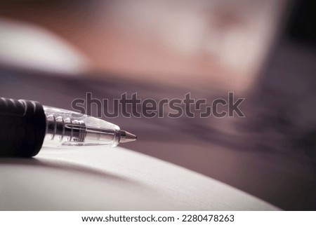 a close - up shot of an open blank notepad for notes , there is a pen on the notebook