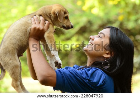 Teenage girl playing with puppy dog Royalty-Free Stock Photo #228047920