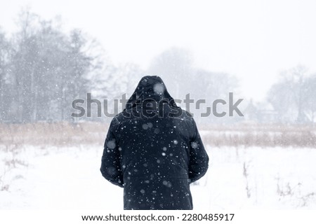 Man walking outdoors when snowing during winter