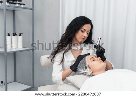 cosmetologist making mesotherapy injection with dermapen on face for rejuvenation. Anti-aging treatment and face lift in cosmetology clinic. medical procedure with Electric pen for derma stamp Royalty-Free Stock Photo #2280492837