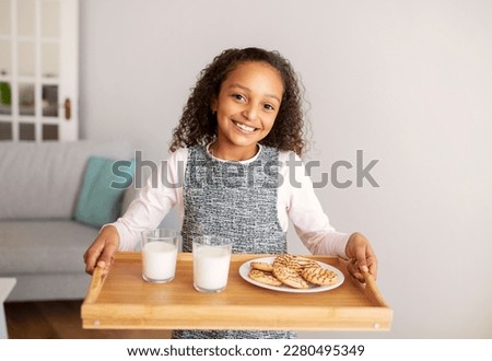 Snack Time. Happy African American Kid Girl Holding Tray With Cookies And Milk For Lunch Carrying Food Smiling To Camera Posing At Home. Preteen Age Child Nutrition Concept