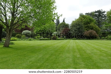 Scenic view of a beautiful landscape garden with a freshly mowed grass lawn and green leafy trees Royalty-Free Stock Photo #2280505219