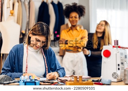Portrait of young beautiful woman fashion designer stylish sitting and working with color samples,dressmaker or tailor.Attractive young girl working with colorful fabrics at fashion studio