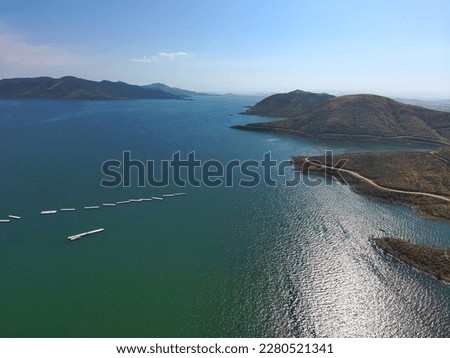aerial shot of a gorgeous summer landscape at Diamond Valley lake with deep blue lake water, blue skies and mountain ranges with blue sky in Hemet California USA	