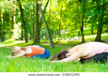 Young women practicing yoga in nature. 