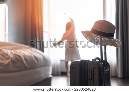 Traveler woman with luggage in business hotel guest room looking out toward city view staying for work travel or vacation trip for traveler Royalty-Free Stock Photo #2280524823