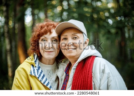 Multiracial old women having a good day in to the wood. Lifestyle, emotion and female friendship concept.