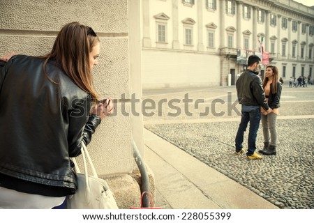Stalking - Ex girlfriend spying her ex boyfriend with another woman - stalking,infidelity and jealousy concepts Royalty-Free Stock Photo #228055399