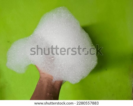hand full of foam on green background