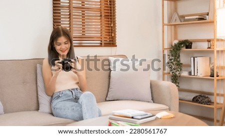 Creative design concept, Fashion designer sits on couch to checking photo of new clothes in camera.