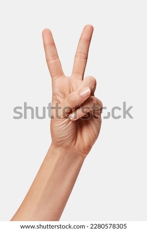 Woman hand showing Win sign isolated, two fingers up Royalty-Free Stock Photo #2280578305