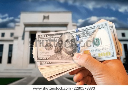 dollars in a man's hand on the background Federal Reserve Building in Washington DC, United States, FED Royalty-Free Stock Photo #2280578893