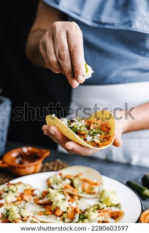 Mexican woman hands preparing tacos al pastor and eating mexican food in Mexico Latin America Royalty-Free Stock Photo #2280603597