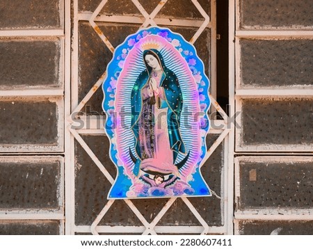 colorful virgin mary painting with lights around on a house window Royalty-Free Stock Photo #2280607411