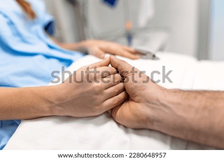 Friendly doctor hands holding patient hand support and hope concept. Male doctors in uniform , holding hands with female patients to encourage patient. encourage and empathy at nursing hospital ward.