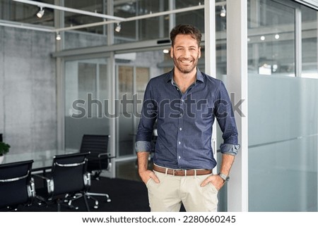 Portrait of mature successful man with hands in pocket standing outside office conference room. Businessman standing in office while looking at camera. Satisfied man in formalwear with copy space. Royalty-Free Stock Photo #2280660245