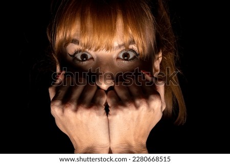 Portrait of scared young woman of something in the dark