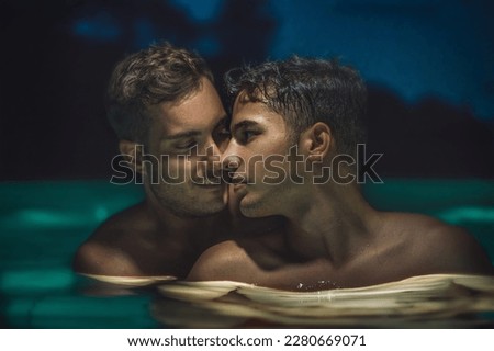Gay couple relaxing in swimming pool at night. LGBT. Two young men kissing and hugging. Young men romantic family in love. Happiness concept Royalty-Free Stock Photo #2280669071