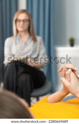 Focus on the hands of a patient lying on the couch at a psychologist's appointment. Woman is being consulted by a psychotherapist. Psychology, psychosomatics, coach. Vertical photo
