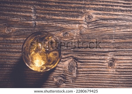 Glass of whiskey on an old wooden table