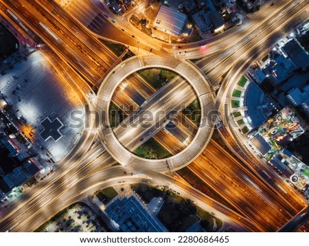 Aerial top view of a illuminated multilevel junction ring road as seen in Attiki Odos toll road motorway interchange with car traffic in Athens, Greece, during night time Royalty-Free Stock Photo #2280686465