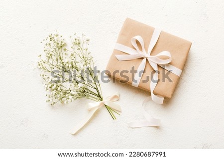 Gift or present box and flower gypsophila on light table top view. Greeting card. Flat lay style with copy space. Royalty-Free Stock Photo #2280687991
