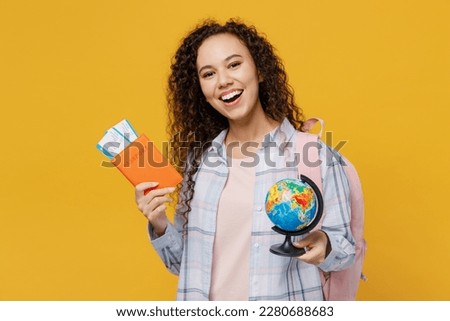 Traveler black teen girl student wear casual clothes hold passport tickets Earth world globe isolated on plain yellow background. Tourist travel high school study abroad getaway. Air flight concept Royalty-Free Stock Photo #2280688683