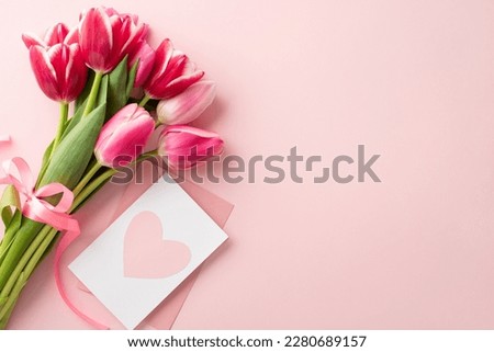 Mother's Day concept. Top view photo of bouquet of pink tulips tied with silk ribbon and envelope with postcard on isolated pastel pink background with copyspace Royalty-Free Stock Photo #2280689157