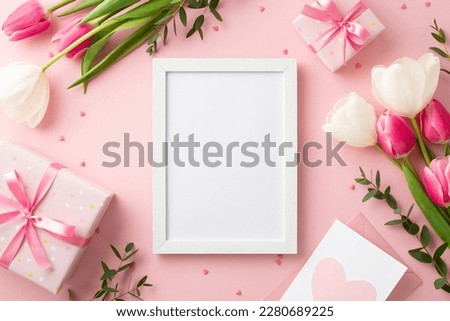 Mother's Day concept. Top view photo of photo frame present boxes with bows bunches of tulips envelope letter and sprinkles on isolated pastel pink background with empty space