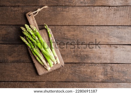 Fresh asparagus on wooden board. Food background Royalty-Free Stock Photo #2280691187