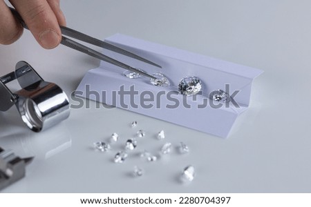 Close up of diamonds of different cuts and sizes on light background with shadows. Royalty-Free Stock Photo #2280704397