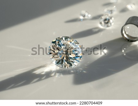 Close up of diamonds of different cuts and sizes on light background with shadows. Royalty-Free Stock Photo #2280704409