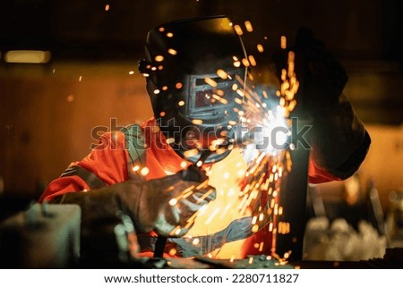 Closeup workers wearing industrial uniforms and using electric arc welding machine to weld steel at factory. Metalwork manufacturing and construction maintenance service by manual skill labor concept. Royalty-Free Stock Photo #2280711827