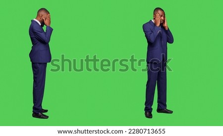 Male entrepreneur dealing with headache over full body green screen background, feeling ill in studio. Young startup manager in suit suffering from migraine and being sick, hurt businessman.