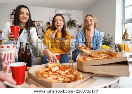 Group of friends with tasty pizza and drinks at home