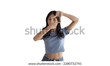 Playful young asian woman in good mood posing for photo or photo frame with fingers on white background,  Use your fingers to act like a photograph, Mark as if taking a photo.