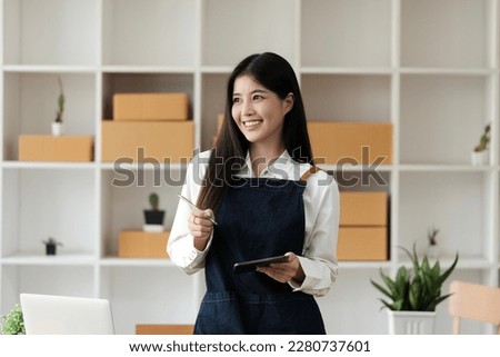 woman entrepreneur thinking and using tablet and parcel box, online business, prepare before delivery