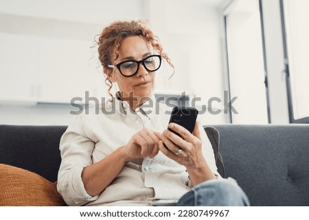 Excited happy young adult woman reading message on mobile phone, getting good news on screen, smiling, laughing, talking on video call, chatting on Internet, using online app. Communication concept Royalty-Free Stock Photo #2280749967