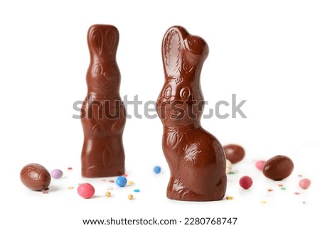 Chocolate Easter bunnies with eggs and sprinkles on white background Royalty-Free Stock Photo #2280768747