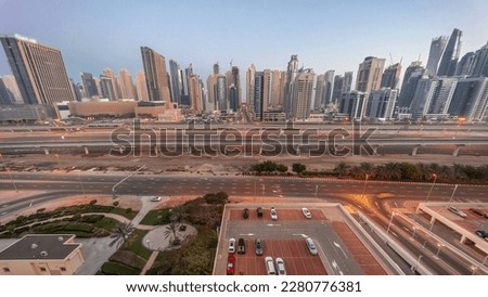 Dubai Marina skyscrapers and Sheikh Zayed road with metro railway aerial night to day transition . Traffic on a highway near modern towers before sunrise, United Arab Emirates