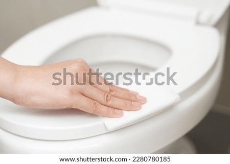 woman using tissue paper clean the toilet in the bathroom at home. Royalty-Free Stock Photo #2280780185