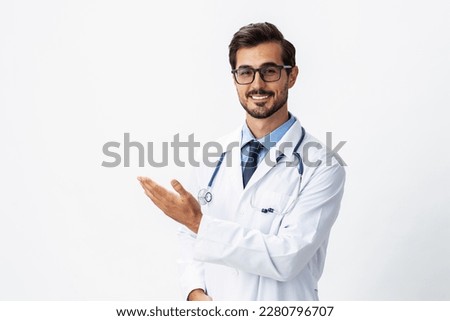 Man portrait doctor in white coat and eyeglasses and stethoscope looking into camera shows hands on background on white isolated background, space for copy, space for text, health Royalty-Free Stock Photo #2280796707