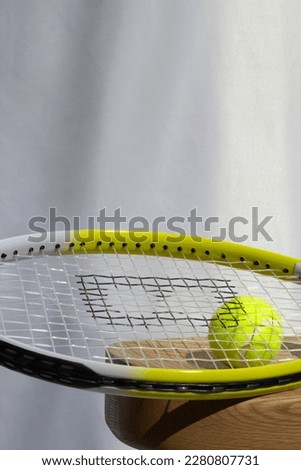 Tennis Racket and Ball on Chair with White Background