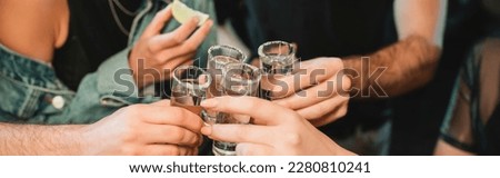 Cropped view of interracial friends holding glasses of tequila in bar, banner Royalty-Free Stock Photo #2280810241