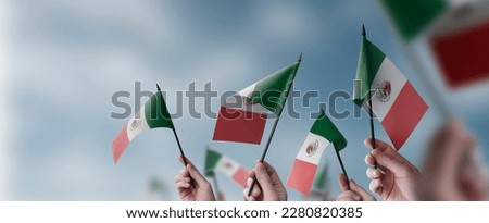 A group of people holding small flags of the Mexico in their hands. Royalty-Free Stock Photo #2280820385