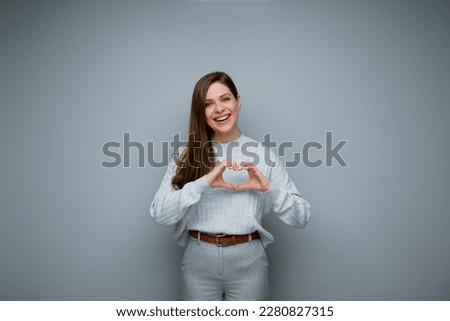 Smiling woman making heart shape with her hands. 