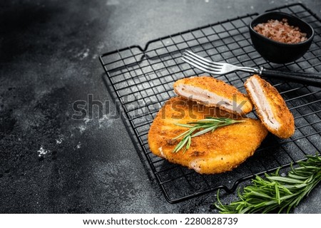 Schnitzel Cordon bleu fillet cutlet with ham and cheese. Black background. Top view. Copy space. Royalty-Free Stock Photo #2280828739