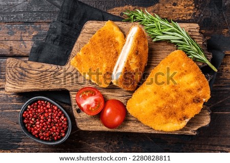 Crispy Cordon Blue Chicken fillet roll with ham and cheese served on a wooden board. Wooden background. Top view. Royalty-Free Stock Photo #2280828811