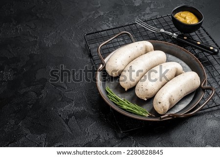 Traditional German Bavarian white sausage in steel tray with mustard. Black background. Top view. Copy space. Royalty-Free Stock Photo #2280828845