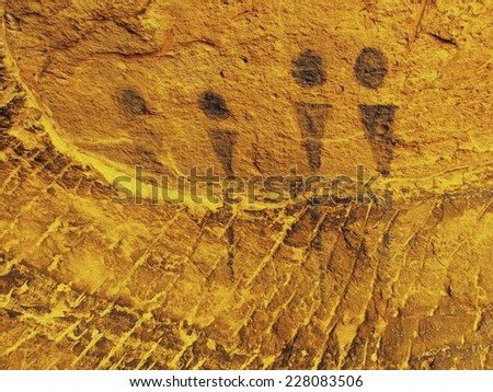 Abstract children art in sandstone cave. Black carbon paint of human hunting on sandstone wall, copy of prehistoric picture. 